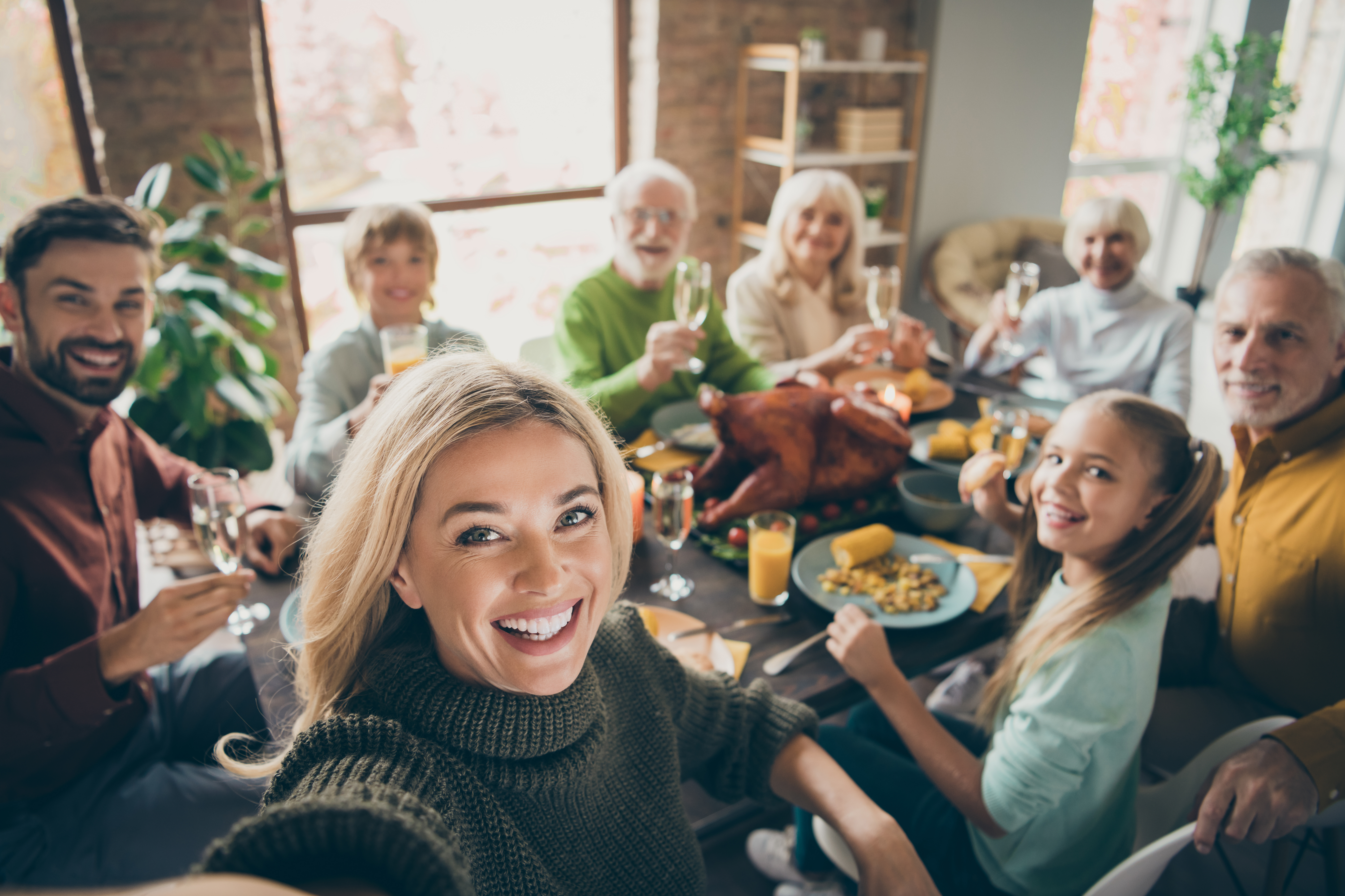 Photo of big family sit feast dishes table around roasted turkey multi-generation, relatives making group selfies raising wine glasses juice in living room indoors